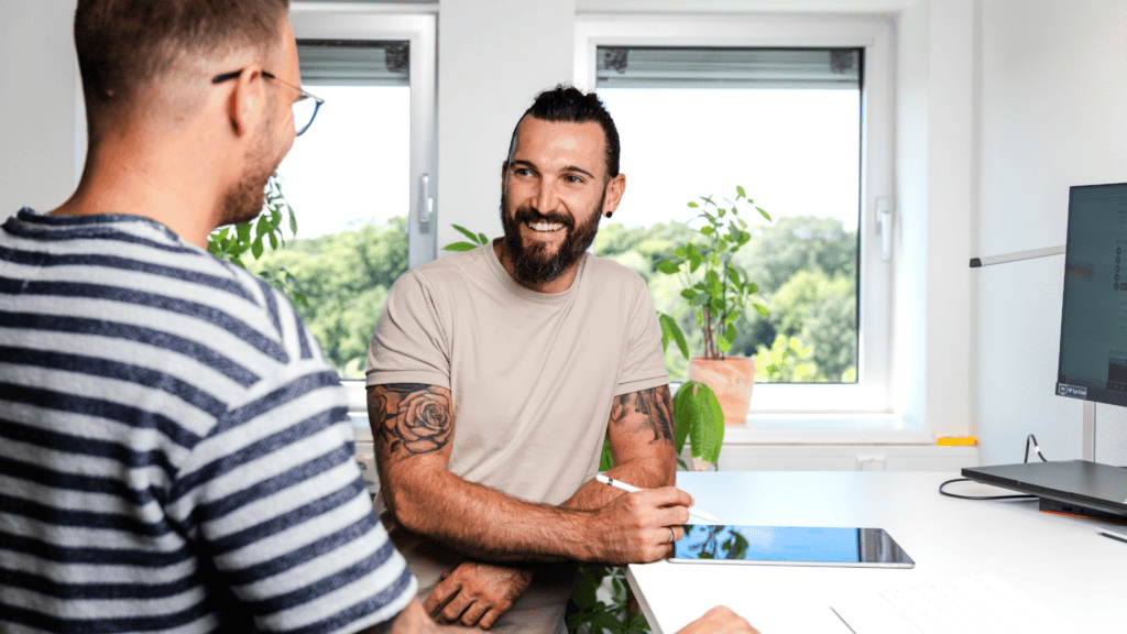 Zwei Kollegen im Gespräch am Schreibtisch