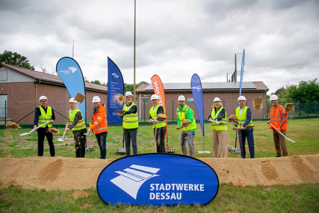 Bauarbeiten in Dessau mit Bauarbeitern und Stadtwerke-Logo.