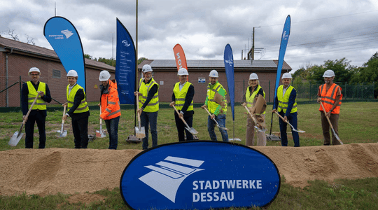 Gruppenfoto von Beteiligten eines Bauvorhabens beim symbolischen Spatenstich